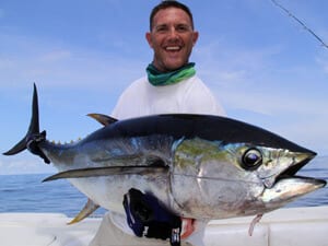 Capt. Shane holding yellowfin tuna aboard the T.O.P. CAT