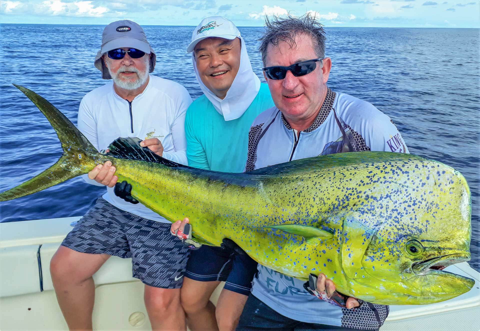 3 anglers holding large bull dolphin