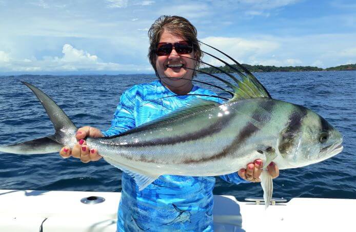 Lady angler posing with Roosterfish. Isla Parida, Panama in the background
