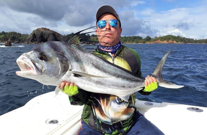Angler posing with roosterfish. Isla Parida, Panama in the background.