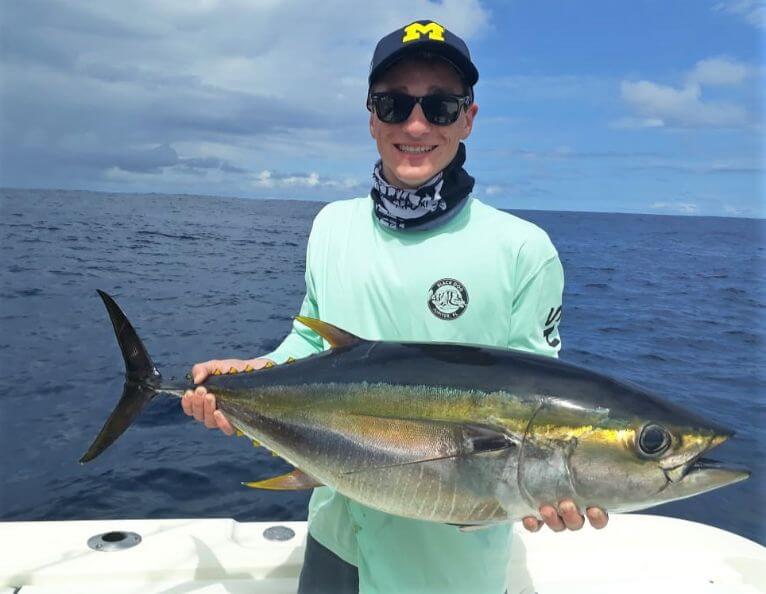 Angler posing with yellowfin tuna...