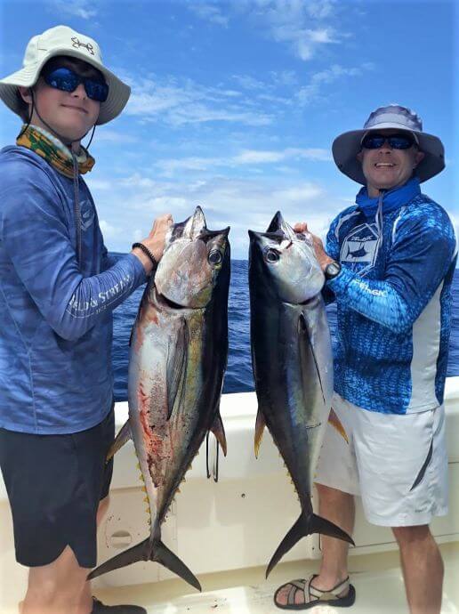 2 anglers posing with yellowfin tunas...
