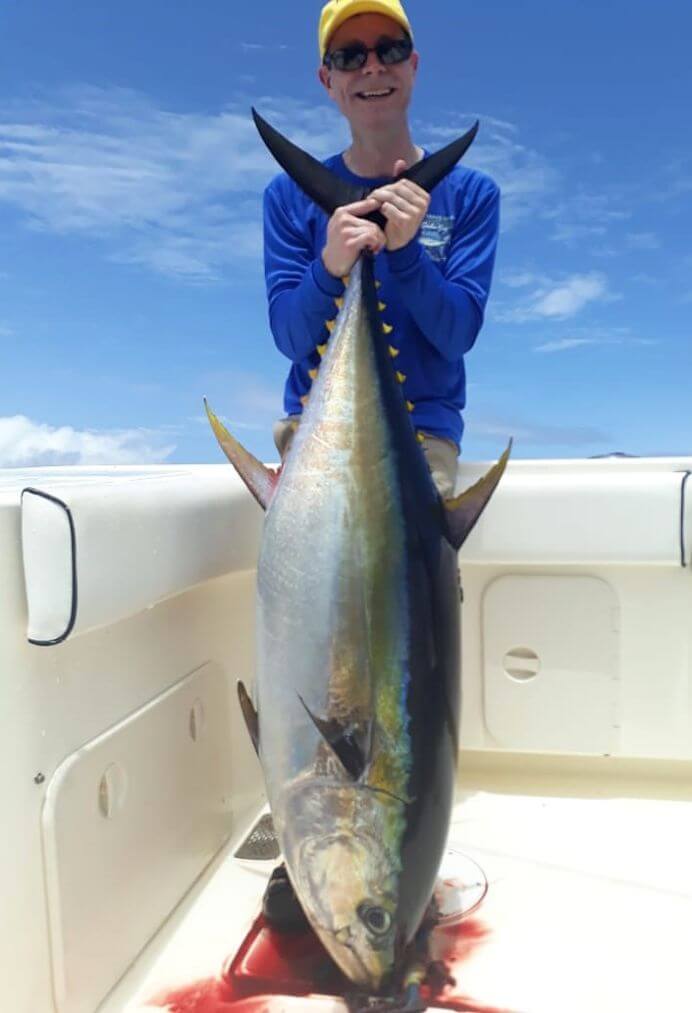 angler posing with large yellowfin tuna