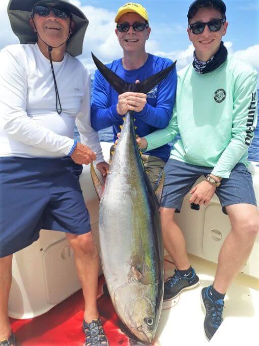 3 anglers posing with yellowfin tuna.
