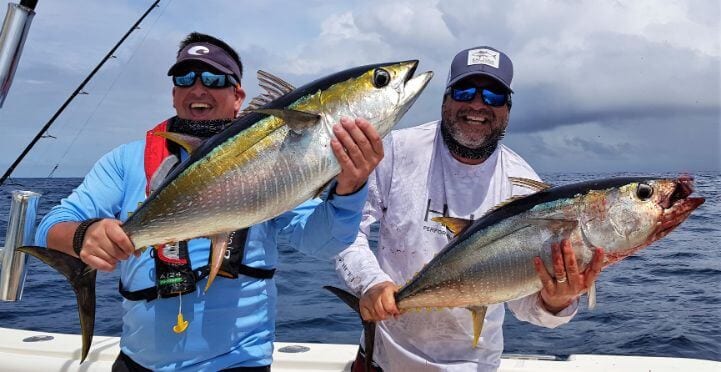 2 anglers posing with yellowfin tunas.
