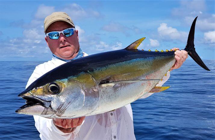 Angler holding small yellowfin tuna while fishing at Sport Fish Panama Island Lodge