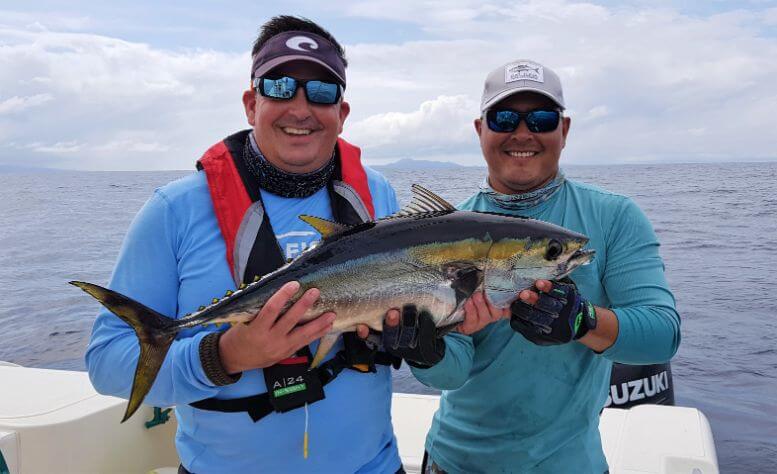 angler and mate with small yellowfin tuna. Isla Montuosa, Panama in background.