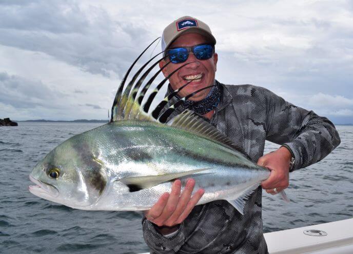 Angler posing with roosterfish. Panama islands in the background