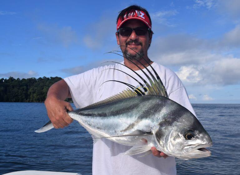Extremely ugly angler with awful beard holding roosterfish