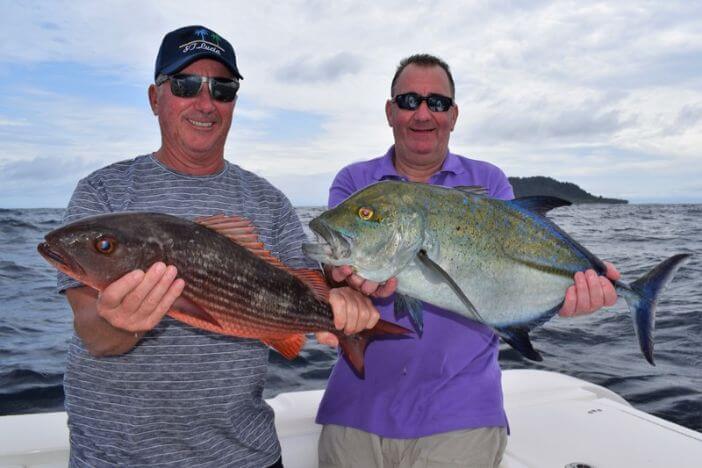 Two anglers posing with just caught fish.  Isla Montuosa, Panama in background.
