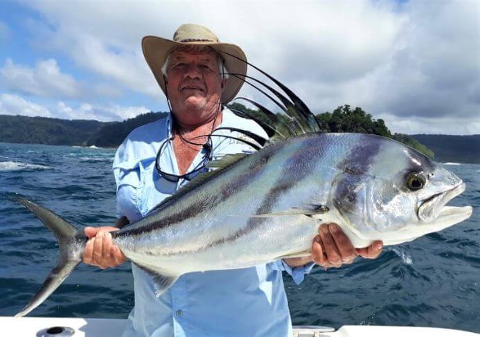 Angler posing with roosterfish.   Isla Parida, Panama in the background.