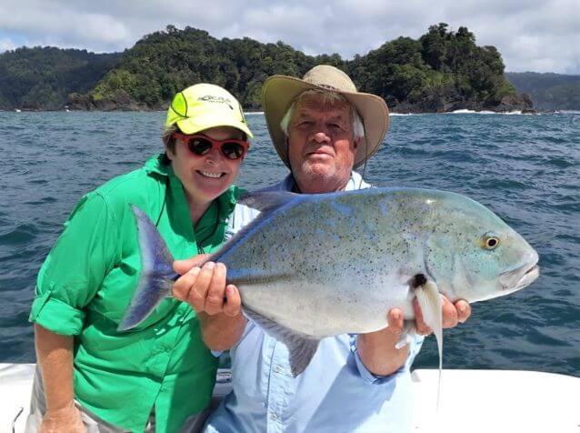 Angling couple posing with Bluefin Trevally
