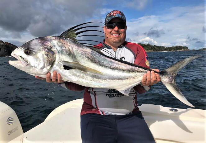 Angler holding roosterfish for picture.