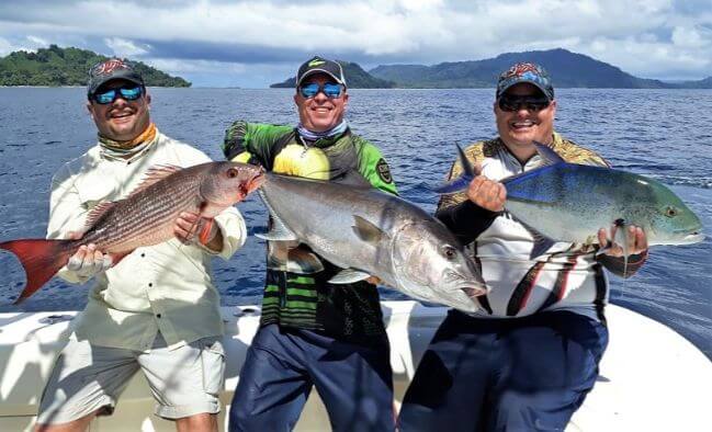 Three smiling anglers posing with Panamanian fish catch