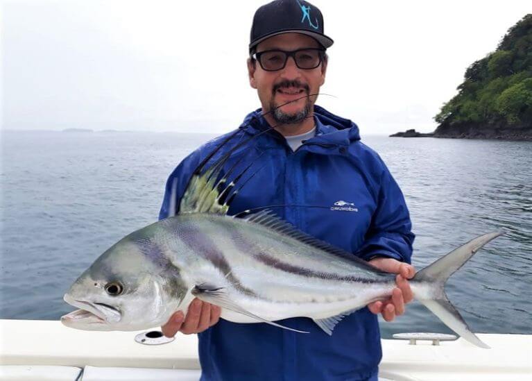 Goofy looking angler holding roosterfish which was probably caught by the mate.
