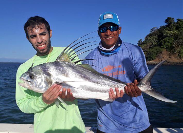 Angler posing with roosterfish with mate in the background