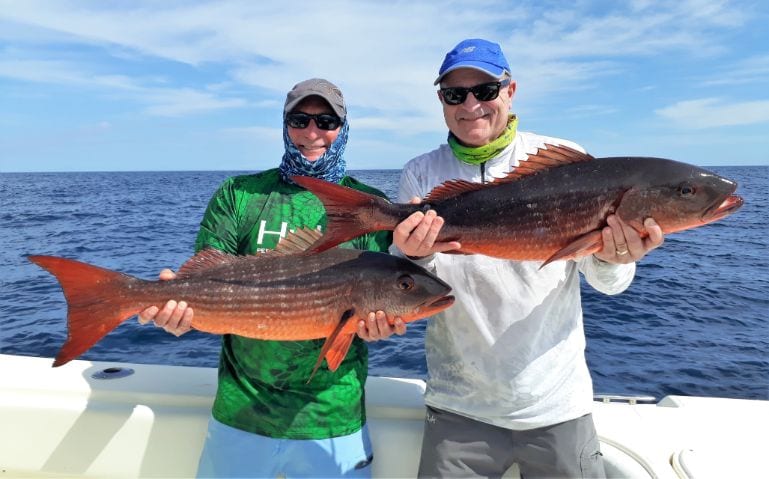 Two anglers posing with small mutton snappers