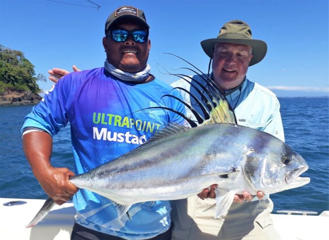 Mate holding roosterfish for anglers picture