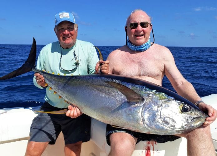 Two anglers holding large Yellowfin Tuna for photo op