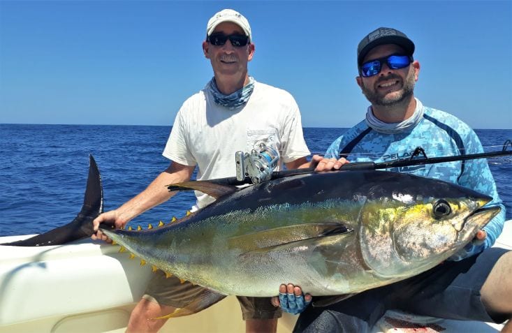 Two smiling Panama anglers holding 80 pound Yellowfin tuna aboard the T.O.P. CAT]