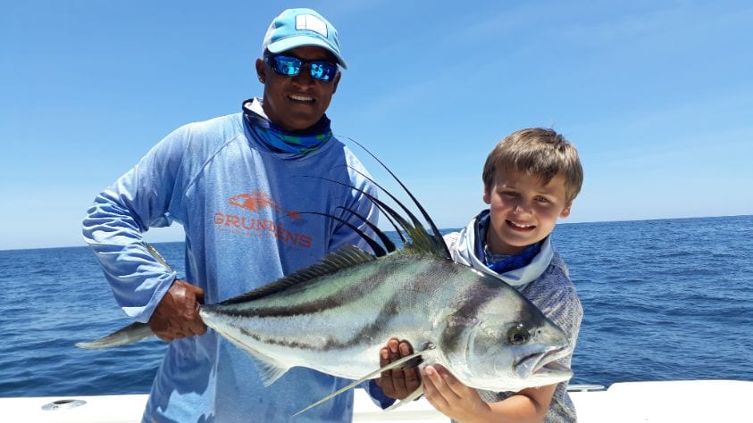 Mate holding roosterfish for junior angler