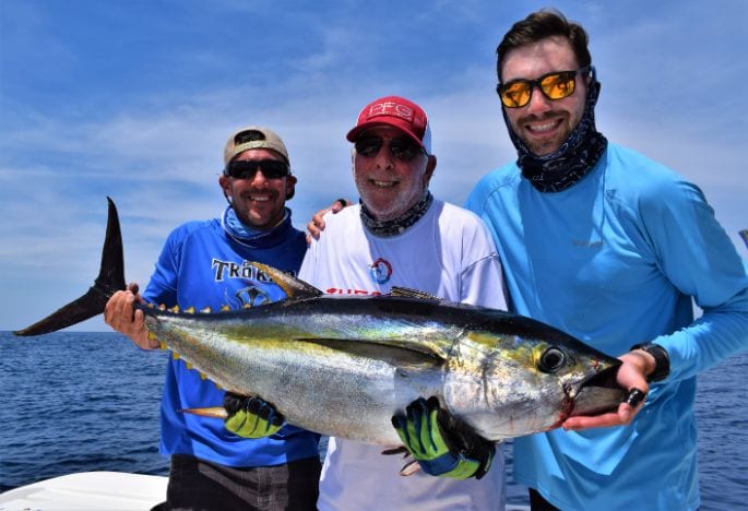 3 anglers posing with small yellowfin tuna