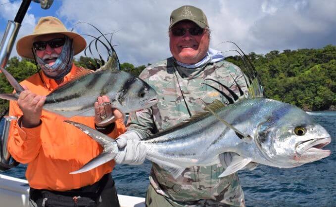 Two anglers posing with two small roosterfish