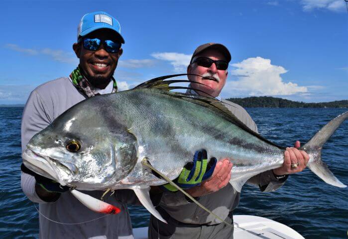 Mate and angler posing with large roosterfish. Isla Parida, Panama in the background.