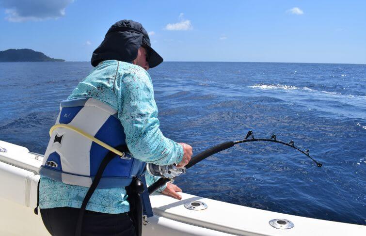 Angler in stand up harness fighting tuna.  Isla Montuosa, Panama in background.