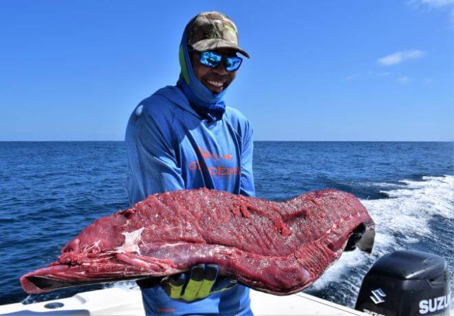 Mate holding large tuna filet.  