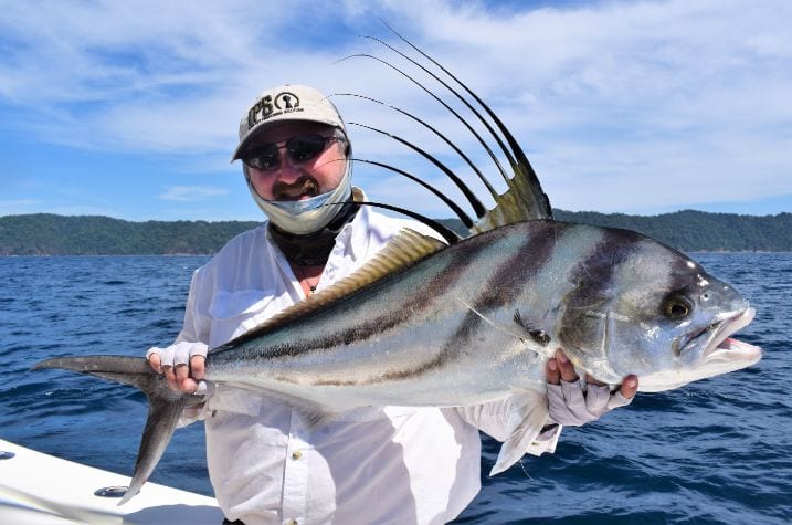 Angler posing with Roosterfish. Isla Parida, Panama in the background