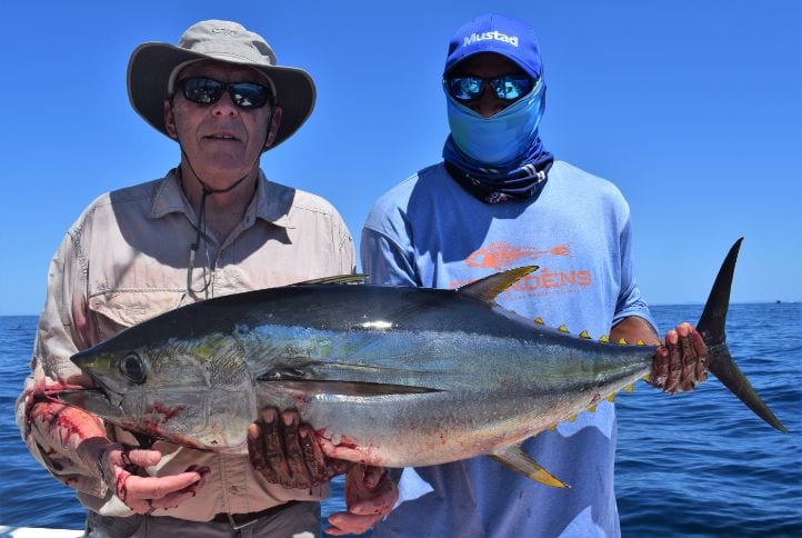 Smiling angler and mate holding 30 pound Yellowfin tuna