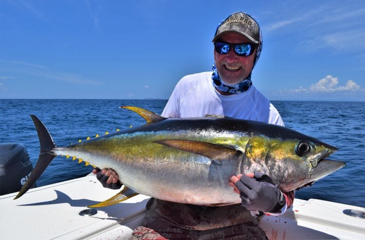 Angler posing for picture holding Yellowfin Tuna