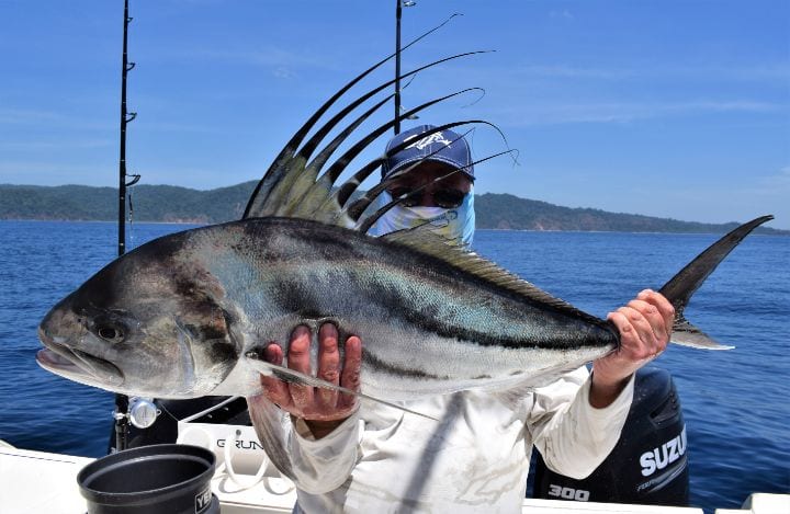 Masked angler posing with roosterfish