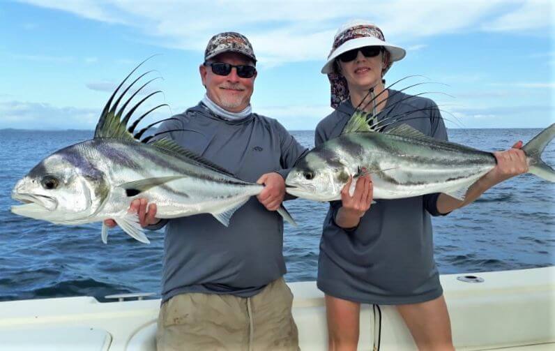 Angeling couple posing with roosterfish