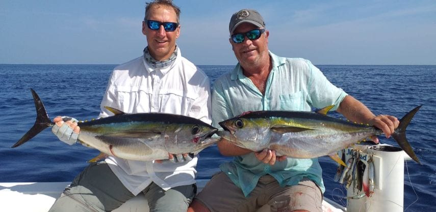  Two smiling anglers holding small yellowfin tunas