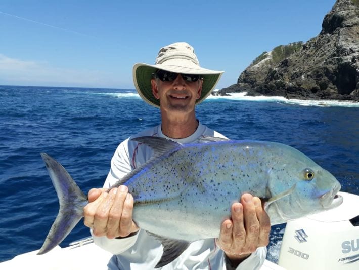 Angler posing with Bluefin Trevally with Isla Ladrones in background