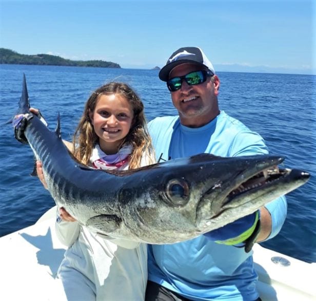 Father and daughter posing with large wahoo