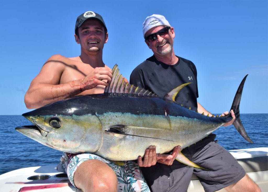 Two anglers holding yellowfin tuna