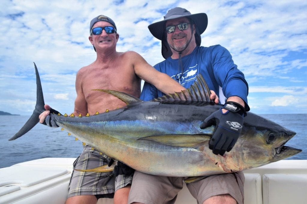 Anglers holding yellowfin tuna for picture