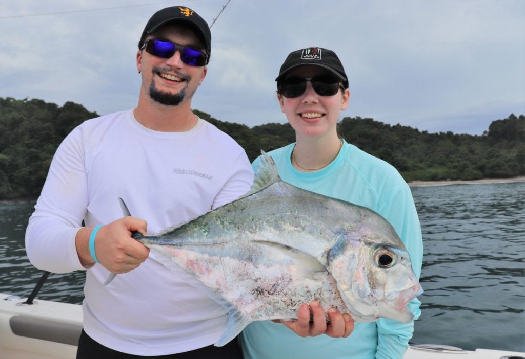 Husband and wife fishing team posing with African Pompano