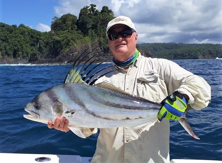 Angler posing with roosterfish. Isla Parida in background
