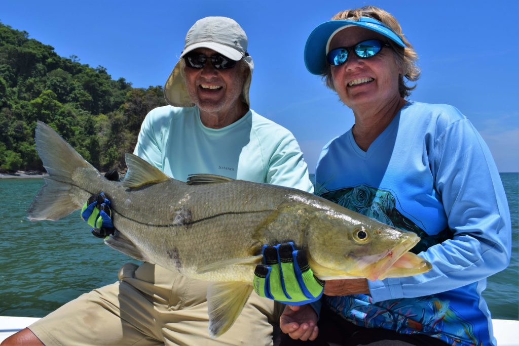couple holding pacific snook during fishing trip