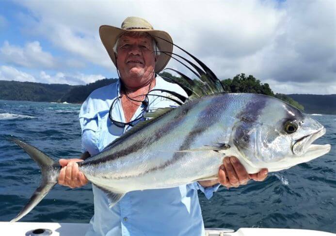 Angler posing with roosterfish. Isla Parida, Panama in the background.