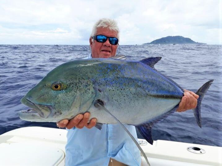 Angler posing with Bluefin Trevally. Isla Montuosa, Panama in background.