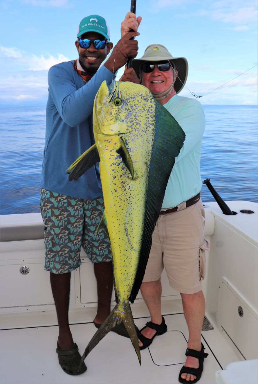 Mate Jonny holding bull dorado for angler posing for picture