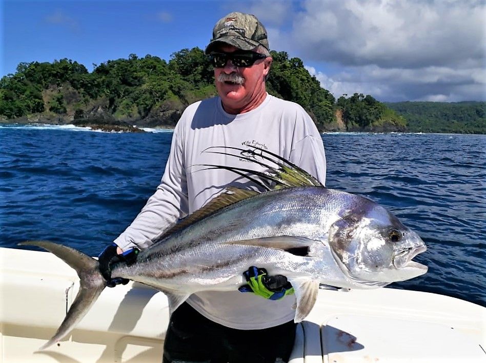 Angler posing with roosterfish. Isla Parida in background